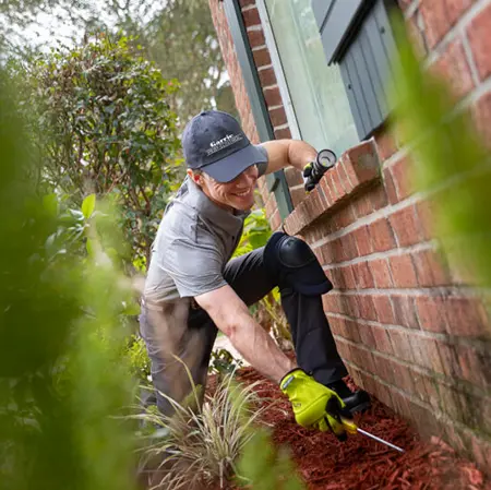 Exterminator inspecting perimeter of a house | Florida Bug Out Pest Control serving Jacksonville, FL 