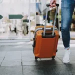 Person rolling suitcase in an airport