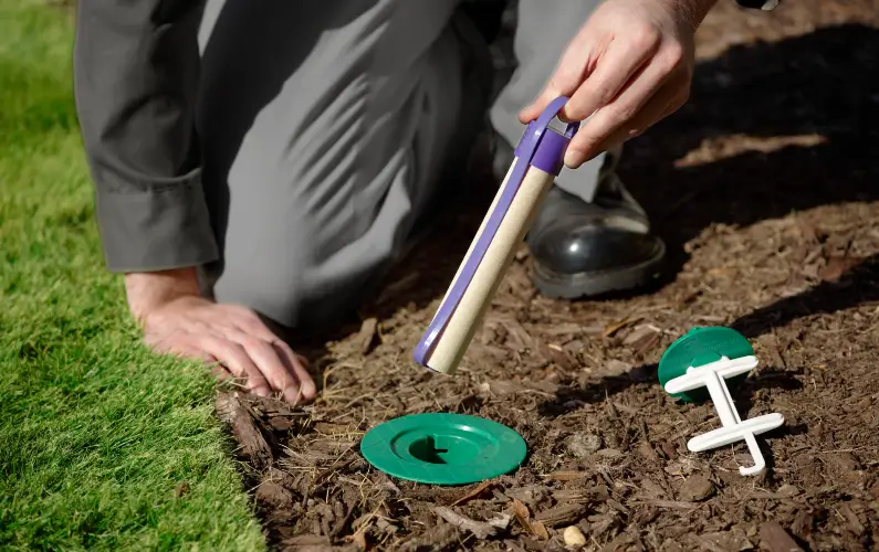 A Bug Out technician holding a Sentricon termite bait station