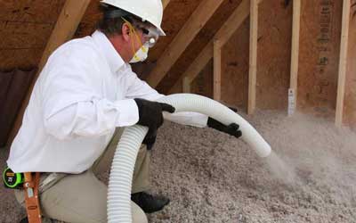 Man installing TAP insulation in a Florida attic